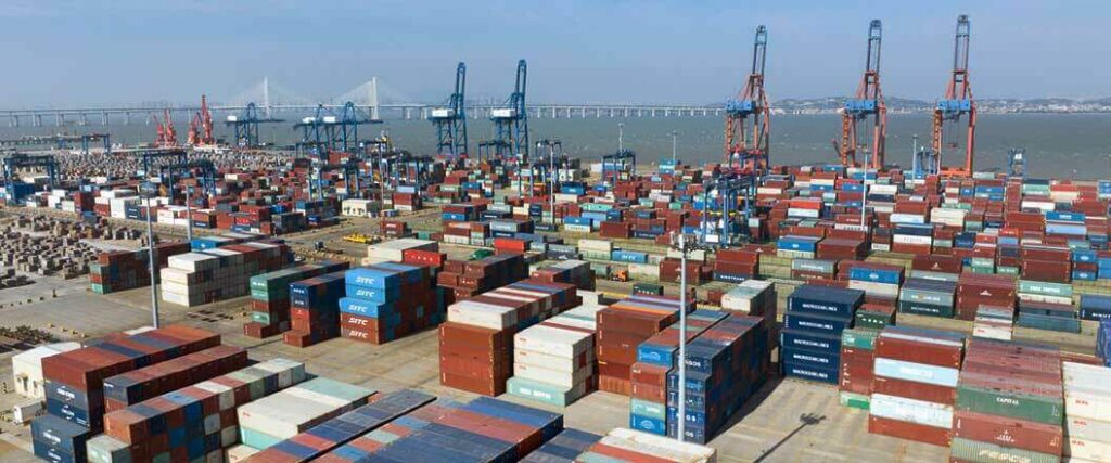 A port with hundreds of 20 and 40-foot shipping containers staged and ready to be loaded.