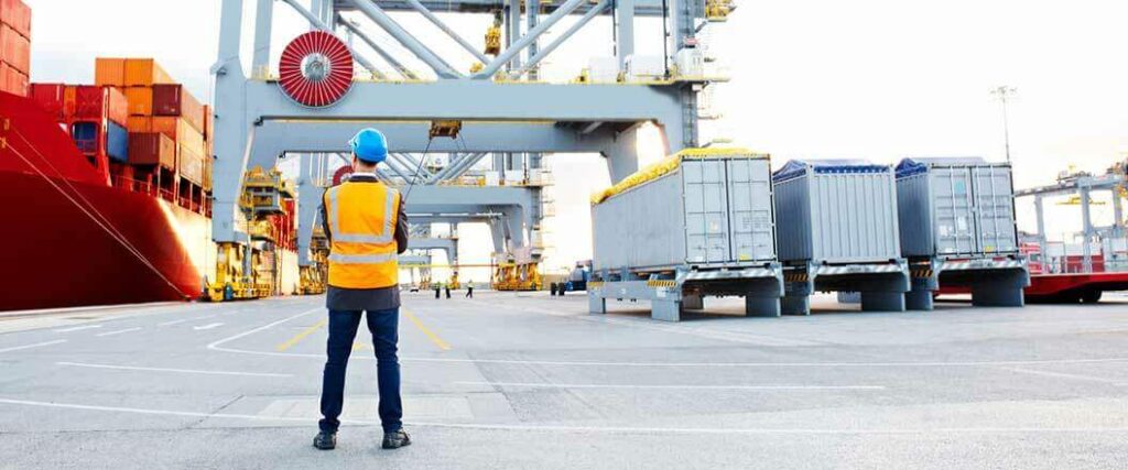 A dock worker watches container loaded at port after the ISF deadline passes.