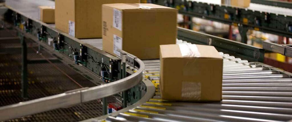 Boxes moving down rollers in a warehouse. 