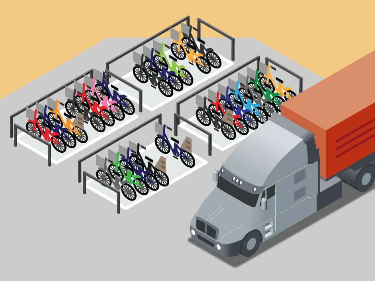 A semi truck pulling a dry van trailer parking next to multiple bicycles