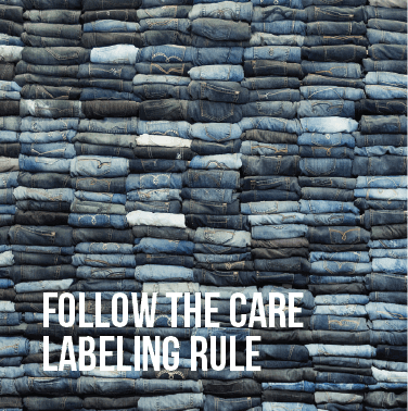 Many pairs of folded jeans stacked on top of one another