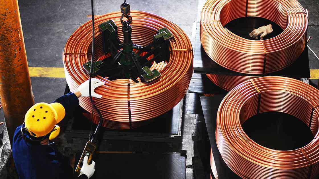 A worker wrapping copper in a circle
