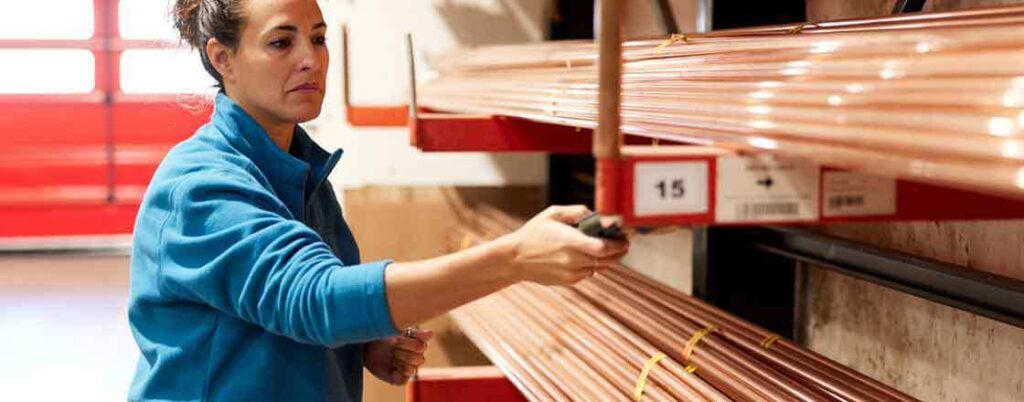 A worker marking copper bars