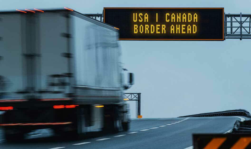 A semi truck approaching the US/Canada border.