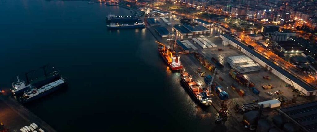 Cargo ships being unloaded at a port at night