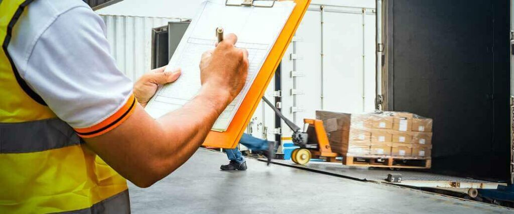 A warehouse worker filling out a checklist.