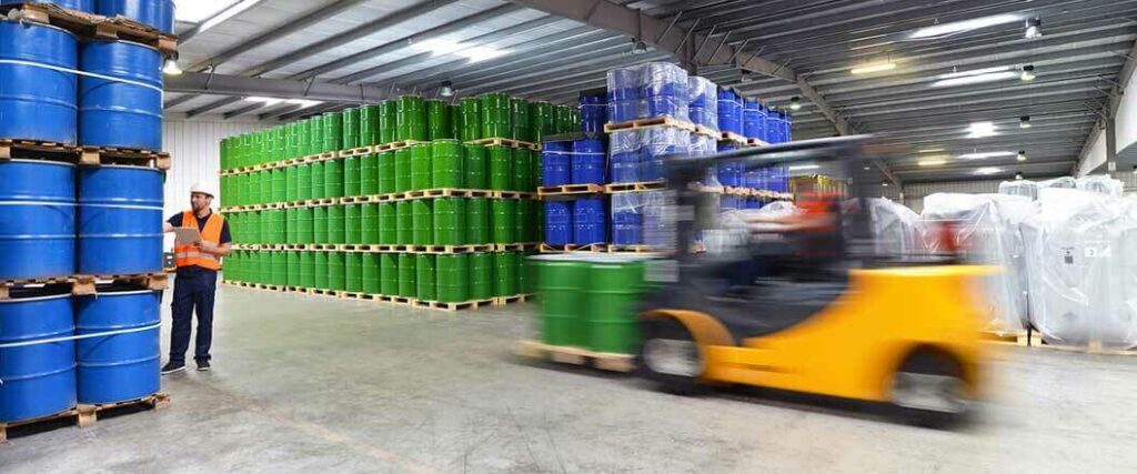 A forklift operator moving a pallet of chemicals in a warehouse.