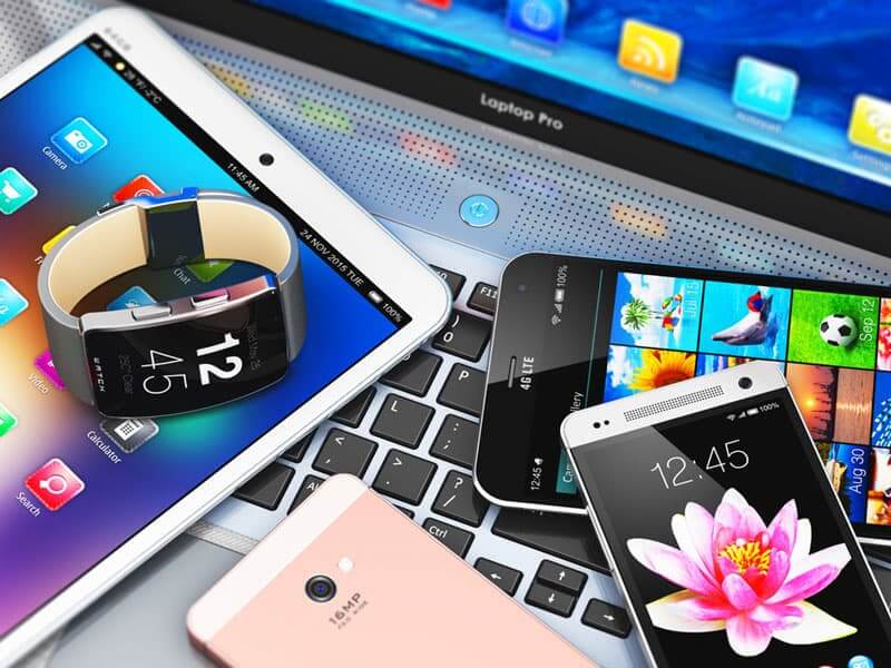 A collage of electronic communications devices including cell phones, a smart watch, and a laptop, reinforcing the section's topic about the Federal Communications Commission